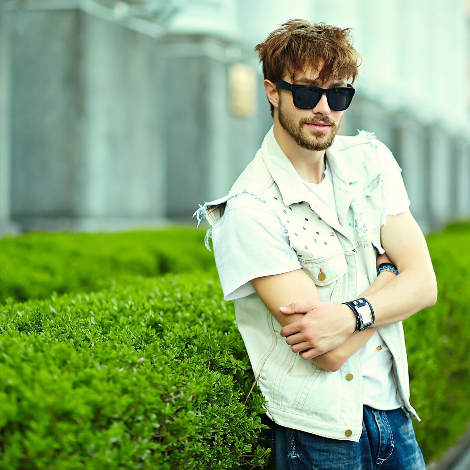 Funny smiling hipster handsome man guy in stylish summer cloth in the street in sunglasses